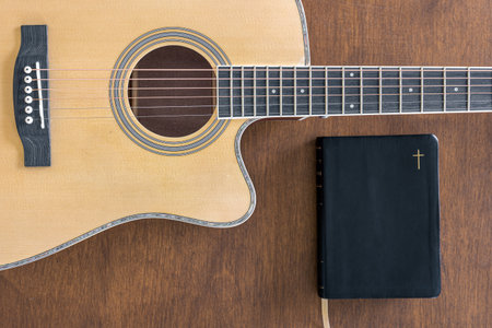 Guitar and bible book on wooden background, top view.の写真素材