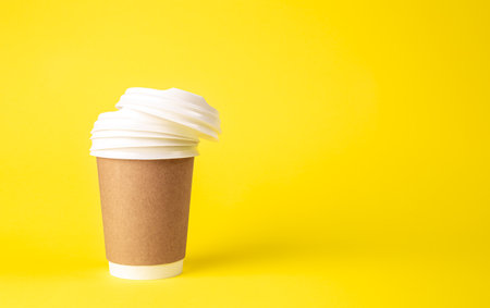 Paper cup and plastic lids on a yellow background isolated.の写真素材