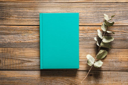 Closed green book on wooden background, top view.の写真素材