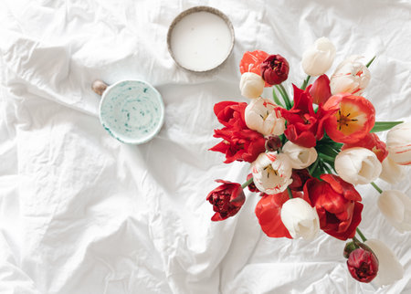 Bouquet of fresh tulips in a white bed, top view.の写真素材