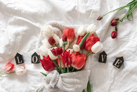 Bouquet of tulips, decorative word Love in a white bed, top view.の写真素材