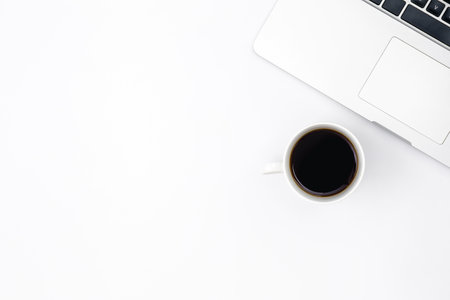 Laptop and a cup of black coffee on a white background, top view.の写真素材