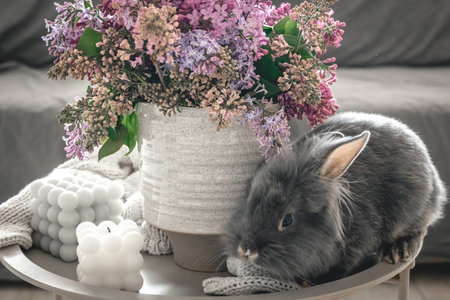 A bouquet of flowers, a rabbit and candles on a blurred background.の写真素材