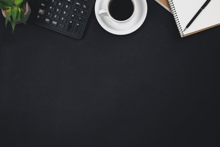A cup of coffee, notepads, a calculator on a black background, top view.の写真素材