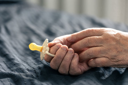 Close-up, a baby pacifier in the hands of a grandmother.の写真素材