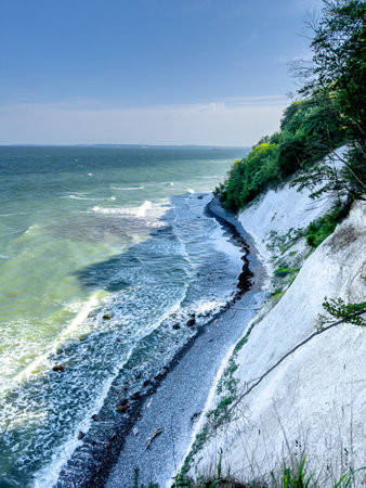 Waves in sea near coastline on empty pebble beach.の写真素材