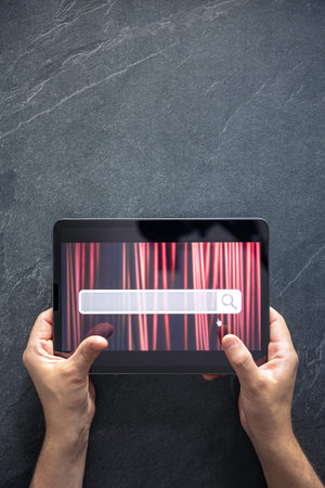 Digital tablet with internet browser search bar on screen in male hands.の写真素材