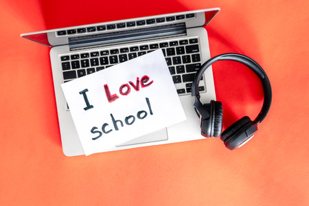 Laptop and headphones on red background, love school concept.の写真素材