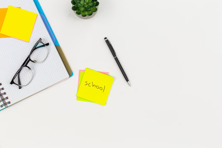 Notepad, glasses, pen and paper reminders on a white background.の写真素材
