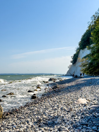 Waves in sea near coastline on empty pebble beach.の写真素材