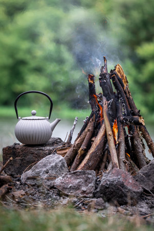 Small kettle is heated on a bonfire, outdoor recreation concept.の写真素材