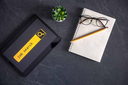 Top view of digital tablet with search job on screen on a table.