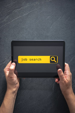 Top view of digital tablet with search job on screen in male hands.の写真素材