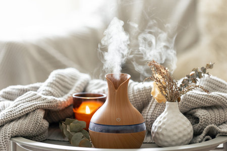 Aroma composition with a modern aroma oil diffuser and a knitted element.