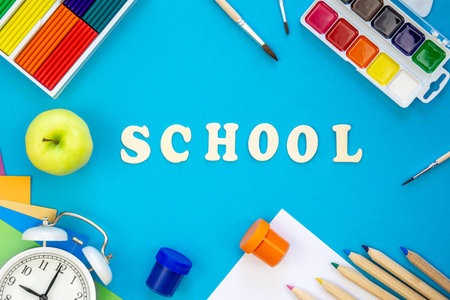 Colourful school supplies on a blue background, back to school concept.