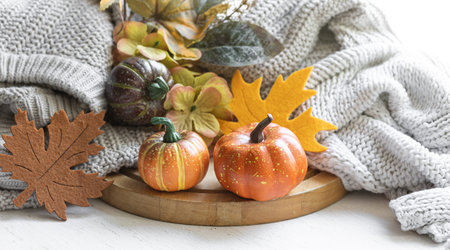 Autumn still life with pumpkins, leaves and knitted element.