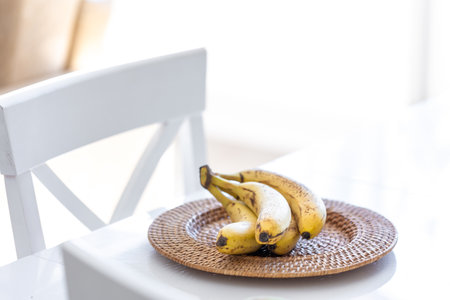 A bunch of ripe bananas in a bright kitchen interior.の写真素材