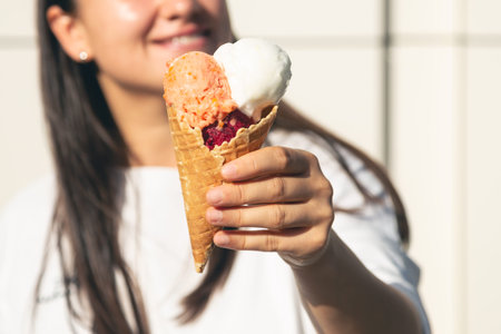 An appetizing ice cream cone in female hands.