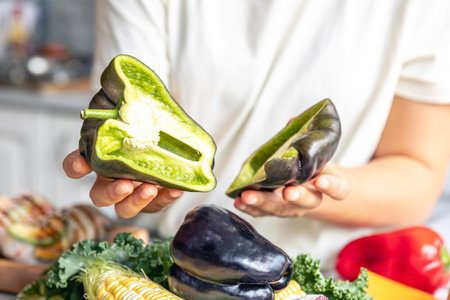 Cut black bell pepper green inside in female hands.の写真素材