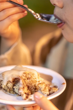 A girl eats a delicious homemade Cinnabon.