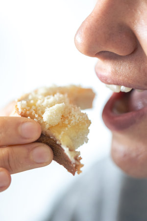A woman eats bread with grated cheese, close-up.