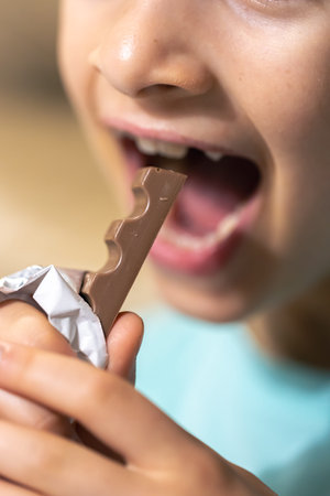 Detailed shot of a girl bites a chocolate bar.