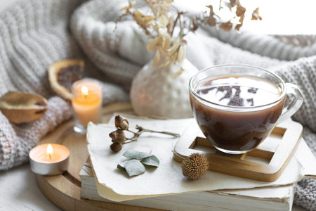 Cozy composition with a cup of tea, books and a knitted element.の写真素材