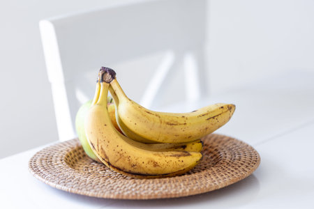 A bunch of ripe bananas in a bright kitchen interior.の写真素材