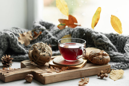 Autumn still life with a cup of tea, cookies and a knitted item.