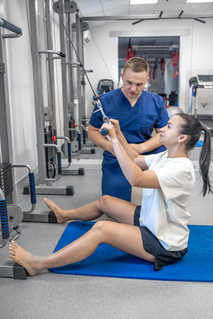 Woman does exercise to stretch back muscles, rehabilitation after injury.の写真素材