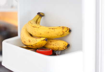 Close-up of bananas on the shelf in open fridge container.の写真素材