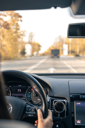 Woman driver hands on steering wheel inside car.の写真素材