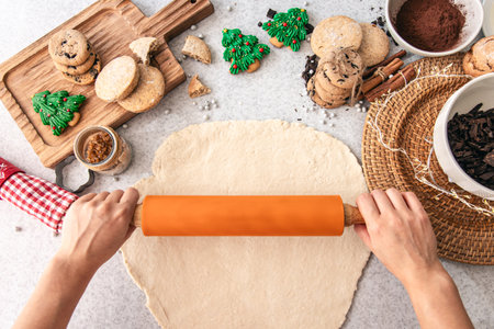 Female hands preparing dough for Christmas cookies on table close up.の写真素材