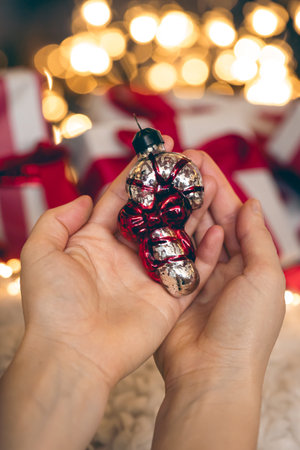 Glass Christmas tree toy in the form of Christmas candy in female hands.の写真素材