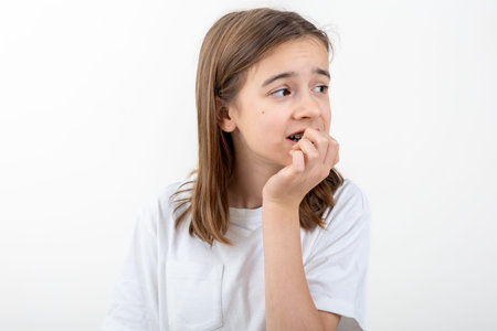 Scared and anxious girl, biting her fingernails on a white background isolated.