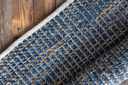 Hand woven geometric denim area rug on wooden floor.