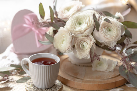 Romantic composition with a cup of tea, gift box and flowers.の写真素材