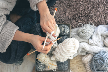 Young woman knitting warm sweater at home, top view.の写真素材