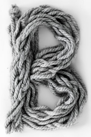 Letter B made from gray threads isolated, top view.
