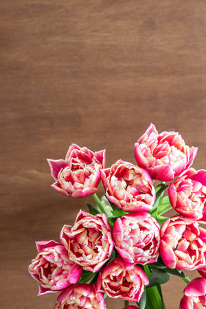 Pink fresh tulips on a wooden table, top view.の写真素材
