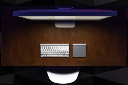 Top view, computer on a wooden table at night, work desk.