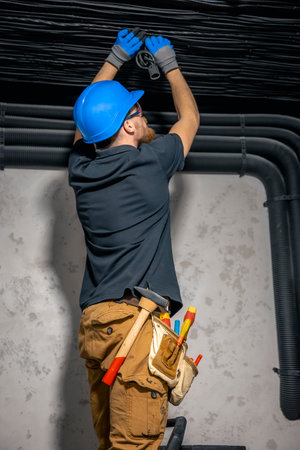 Electrician installing laying electrical cables on the ceiling inside the house.の写真素材