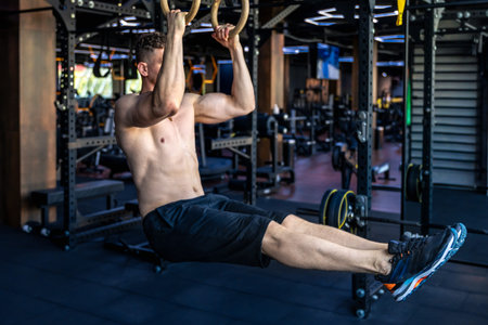 Ahlete doing push-ups in the gym with a bare torso. Sport lifestyle.