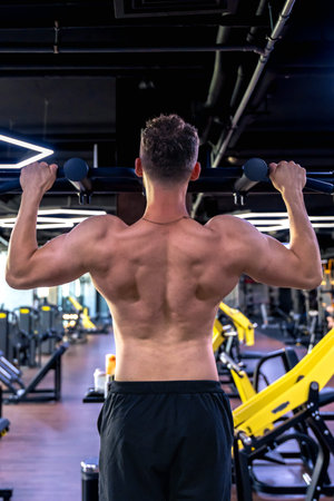 Back view of a man doing push-ups in the gym. Sports lifestyle.