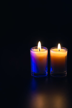 Burning candle on black background with backlight. Memorial Day.の写真素材