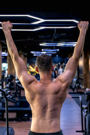 Back view of a man doing push-ups in the gym. Sports lifestyle.の写真素材