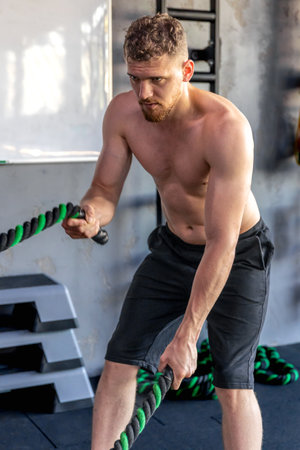 Athlete performs triceps exercises with rope. Sports lifestyle.の写真素材