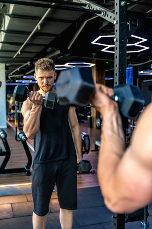 Athlete swings triceps with dumbbells in the gym. Healthy sports lifestyle.の写真素材