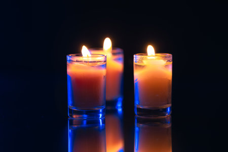 Burning candle on black background with backlight. Memorial Day.の写真素材