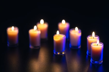 Burning candle on black background with backlight. Memorial Day.の写真素材
